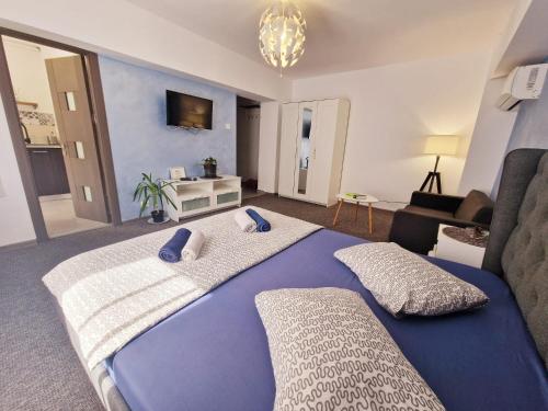 a bedroom with a large bed and a living room at Marcos Apartments - self check-in in Reşiţa