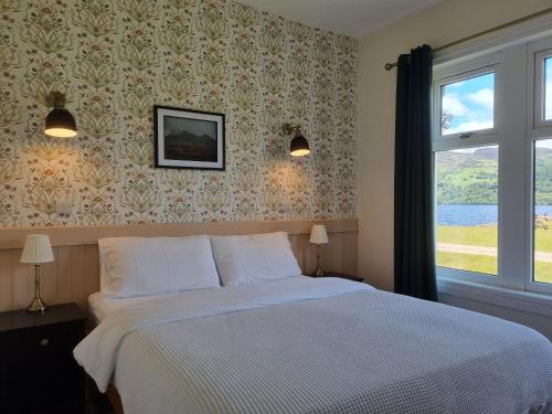 a bedroom with a large bed and a window at The Apartment at Old Pier House in Fort Augustus