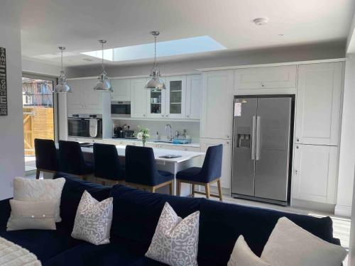 un soggiorno con divano blu e una cucina di Hathaway Beach House a Southbourne