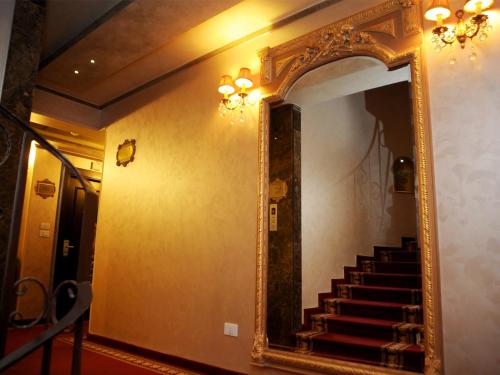 a mirror on a wall in a hallway with stairs at Q Hotel in Beirut