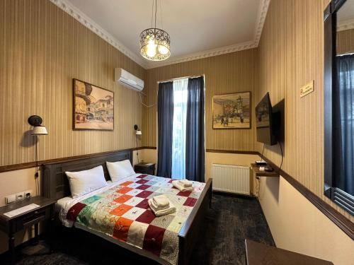 Boutique Hotel Alegria في تبليسي: غرفه فندقيه بسرير ونافذه
