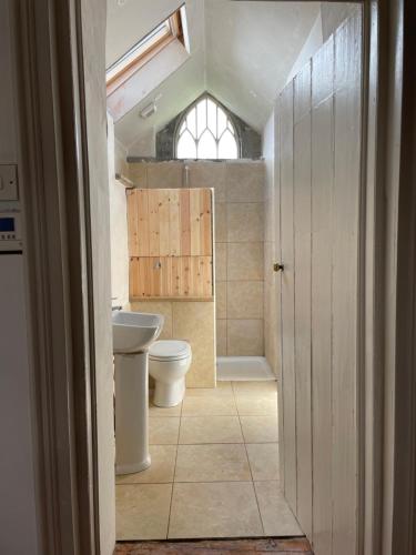 uma casa de banho com um WC, um lavatório e uma janela em Gurteen farm house em Clonmel