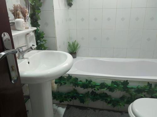 a bathroom with a sink and a tub and a toilet at Private Bedroom in a Home With Park View in Sharjah