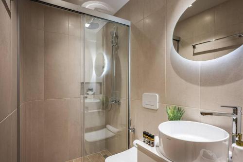 Un baño con ducha, lavabo y espejo. en Amalia's Luxury Apartment 2, en Heraclión