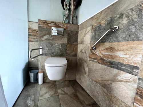 La salle de bains est pourvue de toilettes et d'un mur en pierre. dans l'établissement Apartament Llevant 8, à Lloret de Mar