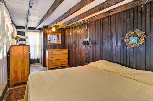 a bedroom with a bed and a wooden wall at Beachfront Connecticut Retreat with Views! in Milford