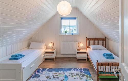 a attic bedroom with two beds and a window at 2 Bedroom Stunning Home In Zerpenschleuse in Berg
