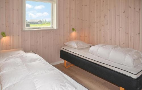StavningにあるNice Home In Skjern With 5 Bedrooms, Sauna And Wifiのベッドルーム1室(ベッド2台、窓付)