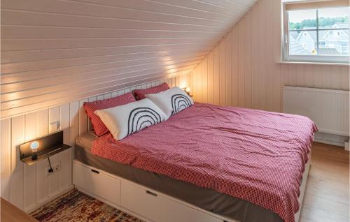 a bedroom with a bed with a red comforter and a window at Amazing Home In Wandlitz With Sauna in Wandlitz