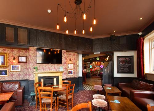 a restaurant with a fireplace and a table and chairs at The Saddle Inn in Chester