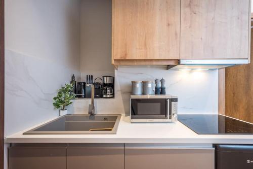 una cucina con lavello e microonde di Amalia's Luxury Apartment 3 a Heraklion