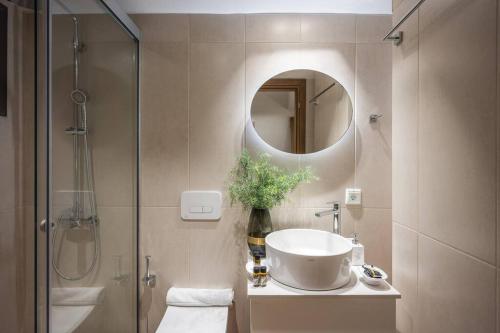 uma casa de banho com um lavatório, um chuveiro e um espelho. em Amalia's Luxury Apartment 3 em Heraclião