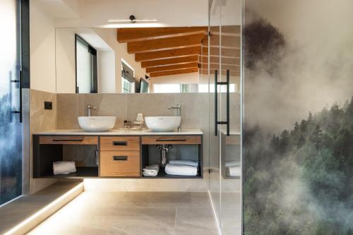 a bathroom with two sinks and a shower at Hotel Garden in Moena