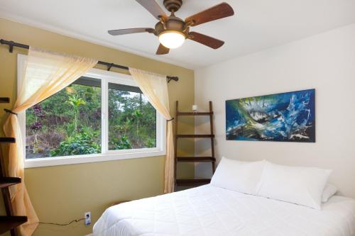 1 dormitorio con cama y ventana en Keaau Gardens, en Keaau