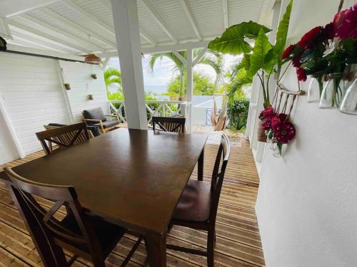 - une salle à manger avec une table, des chaises et des fleurs dans l'établissement La p’tite barque Antillaise, à Deshaies