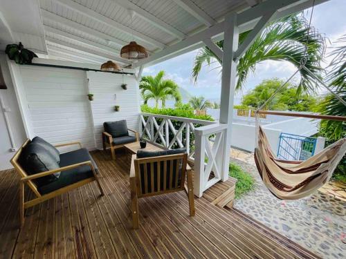 - une terrasse couverte avec un hamac et une balançoire dans l'établissement La p’tite barque Antillaise, à Deshaies