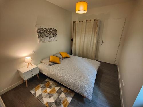 a bedroom with a bed with yellow pillows and a lamp at 4 en 1- jusqu'à 14 personnes in Riom