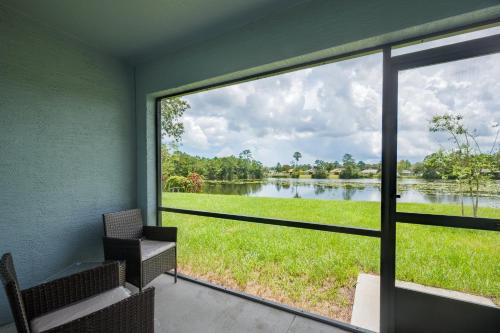 パーム・コーストにあるSea Breeze Lake Villa Bの窓から湖の景色を望む客室です。