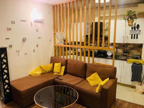 uma sala de estar com um sofá castanho com almofadas amarelas em Muhammad homes&land em Islamabad