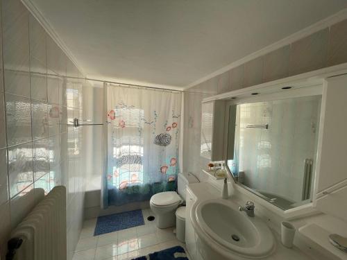 a bathroom with a toilet and a tub and a sink at Jenny's Villa - Lagonissi in Kalívia Thorikoú