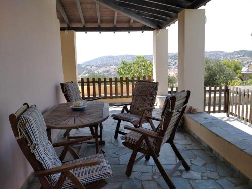a patio with a table and chairs on a porch at Jenny's Villa - Lagonissi in Kalívia Thorikoú