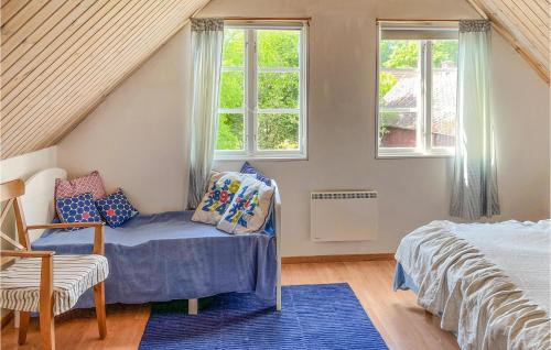 a bedroom with a bed and a chair and windows at Gorgeous Home In Vittsj With House A Panoramic View in Vittsjö