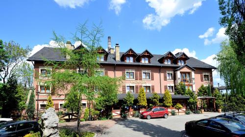 a large building with cars parked in front of it at Hotel Diament Vacanza Katowice - Siemianowice in Siemianowice Śląskie