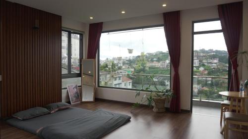 a bedroom with a bed in front of large windows at Hoshi DaLat House in Da Lat