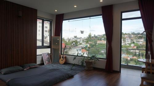 a bedroom with a bed and a large window at Hoshi DaLat House in Da Lat