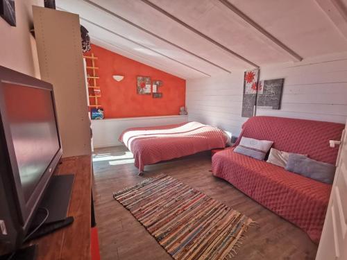 salon z czerwoną kanapą i telewizorem w obiekcie Entre Ventoux et Luberon, appartement dans maison. w mieście Malemort-du-Comtat