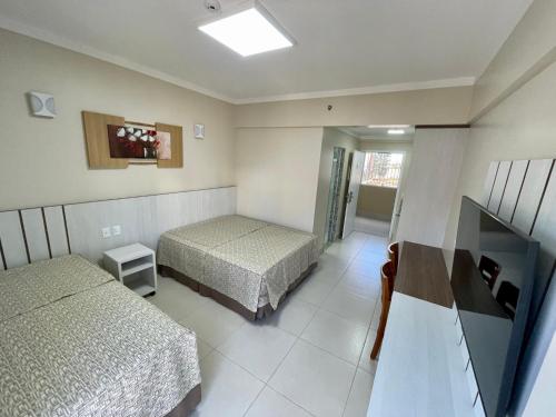 a hotel room with two beds and a television at Spazzio Diroma com acesso ao Acqua Park todos os dias in Caldas Novas