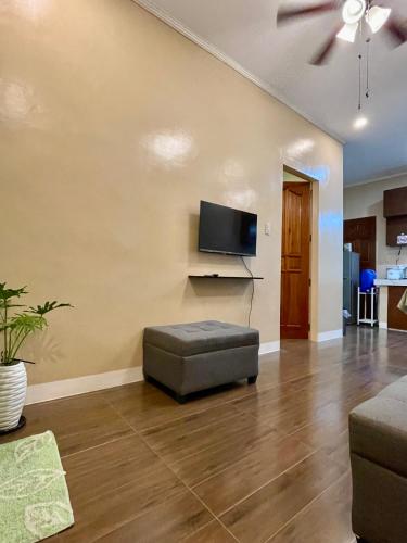 a living room with a couch and a flat screen tv at Patterville Transient House in Iba