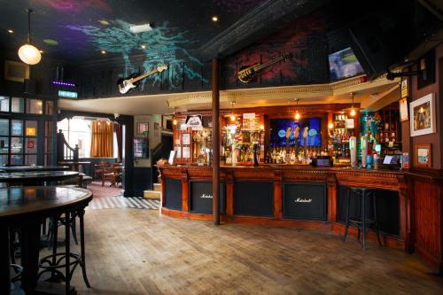 un bar dans un pub avec un comptoir et des tables dans l'établissement The Saddle Inn, à Chester