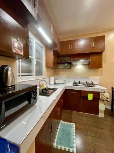 a kitchen with wooden cabinets and white counter tops at Patterville Transient House in Iba