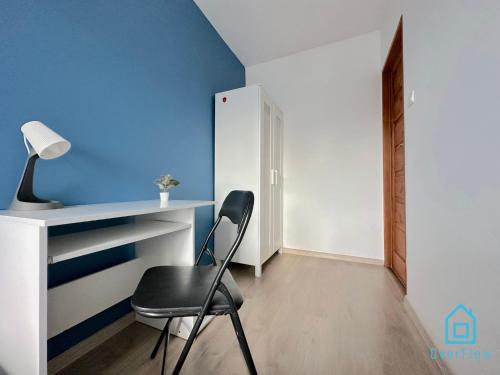 a chair in a room with a blue wall at Colourful Room in Gdańsk