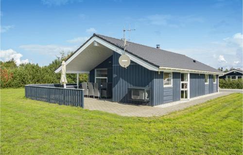 a blue house with a lawn in front of it at Holiday Home Fasanvænget Hemmet I in Hemmet