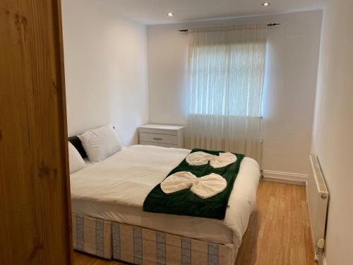 een slaapkamer met een bed met twee handdoeken erop bij The London apartment in Londen