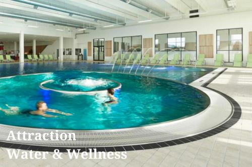 two people swimming in a pool with a water fountain at Casa Jakobsen in Randers