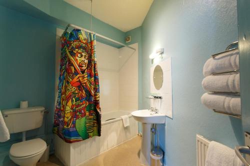 a bathroom with a toilet and a sink and a shower curtain at The Saddle Inn in Chester