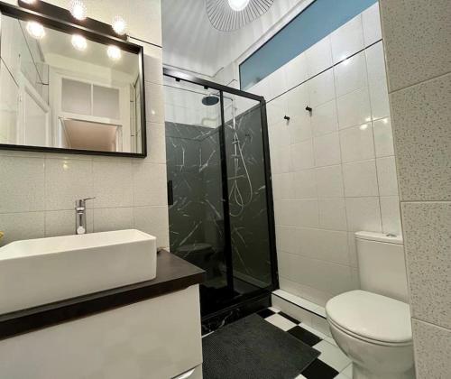a bathroom with a sink and a toilet and a mirror at 2 pièces cocooning près du port/gare riquier in Nice
