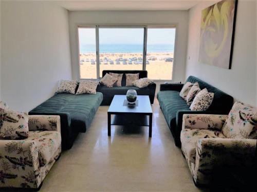 a living room with couches and a coffee table at Plage de rêve in Imi Ouaddar