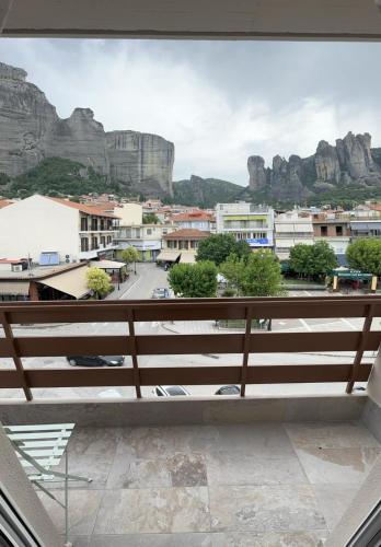 a balcony with a view of a city and mountains at Meteora Gold and Glass in Kalabaka