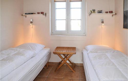 sypialnia z 2 łóżkami i małym stołem w obiekcie Lovely Home In Tarm With Kitchen w mieście Fjerbæk