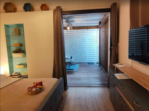 a bedroom with a door open to a hallway with a television at Bungalow les Songes in Étang-Salé