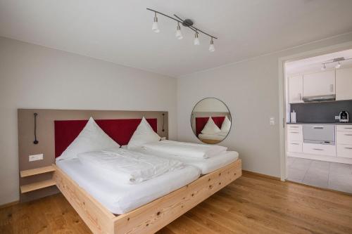 a bedroom with a large bed with a red headboard at SEEZEIT Residence in Hagnau