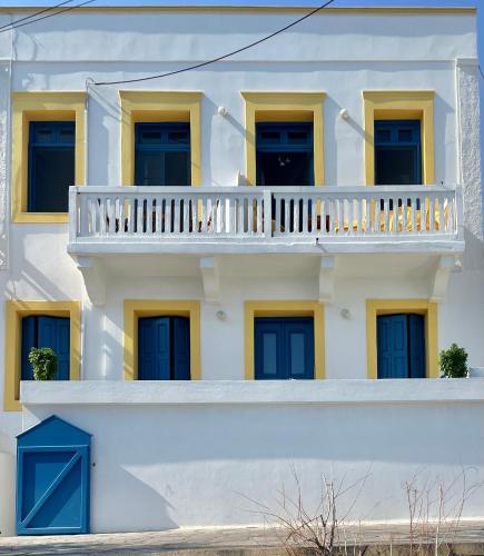 a white building with blue doors and a balcony at Vera Mare in Agia Marina