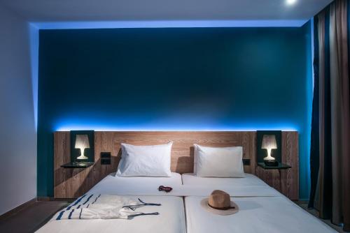 a bedroom with a bed with a blue wall at Infinity Blue Boutique Hotel & Spa - Adults Only in Hersonissos