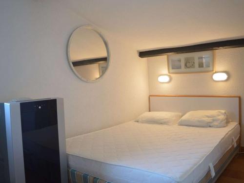 Dormitorio pequeño con cama y espejo en Appartement La Croix-Valmer, 3 pièces, 6 personnes - FR-1-226B-152, en La Croix-Valmer