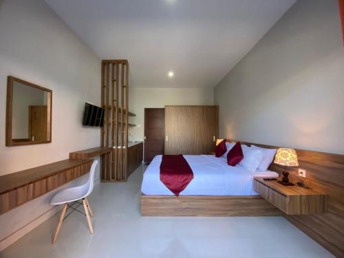 a bedroom with a large white bed and a chair at Pondok Puspa Sumekar in Seminyak