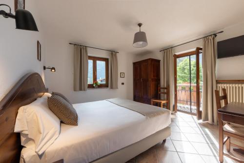 a bedroom with a bed and a desk and a window at Le Rêve in Courmayeur